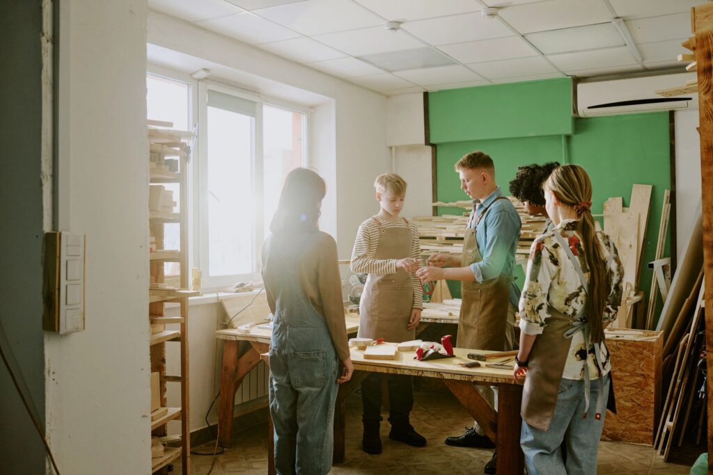 Teenagers Learning Woodworking Skills in Vocational Workshop