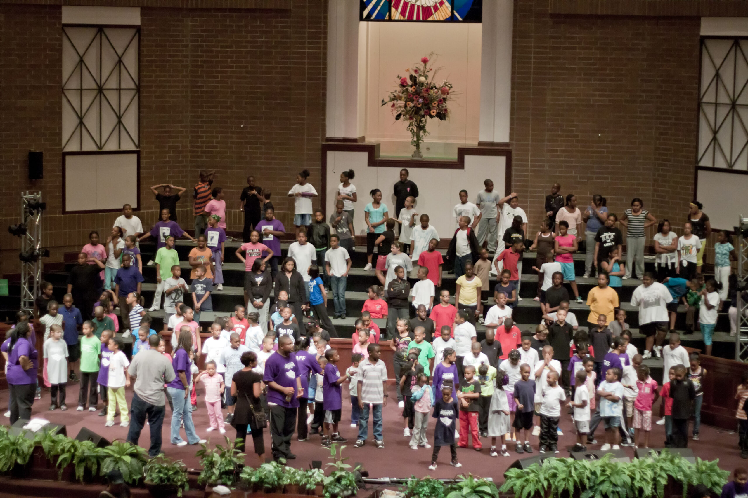 Paneh youth and community members gathered on a church stage during an event