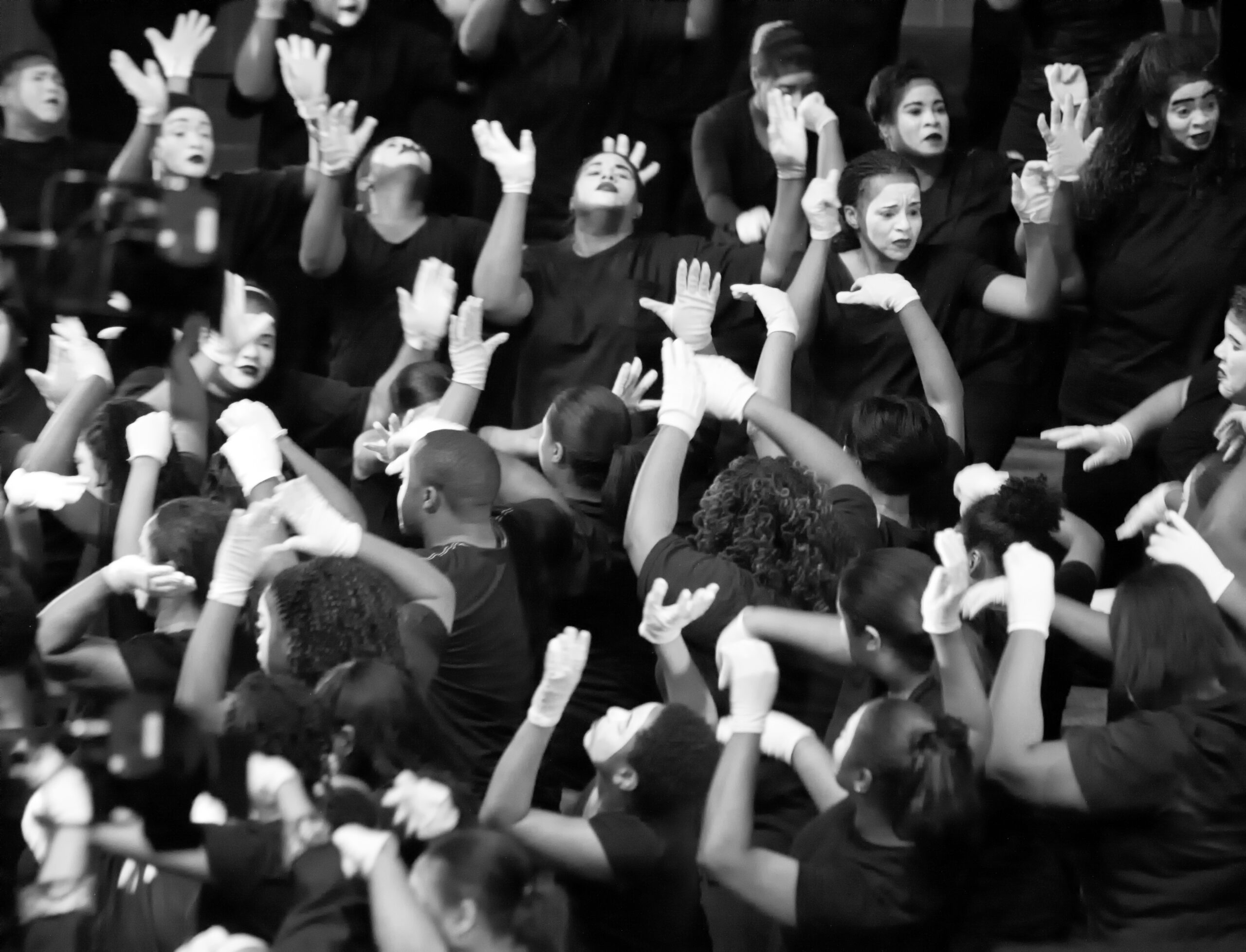 Children on stage with raised hands during a worship arts performance